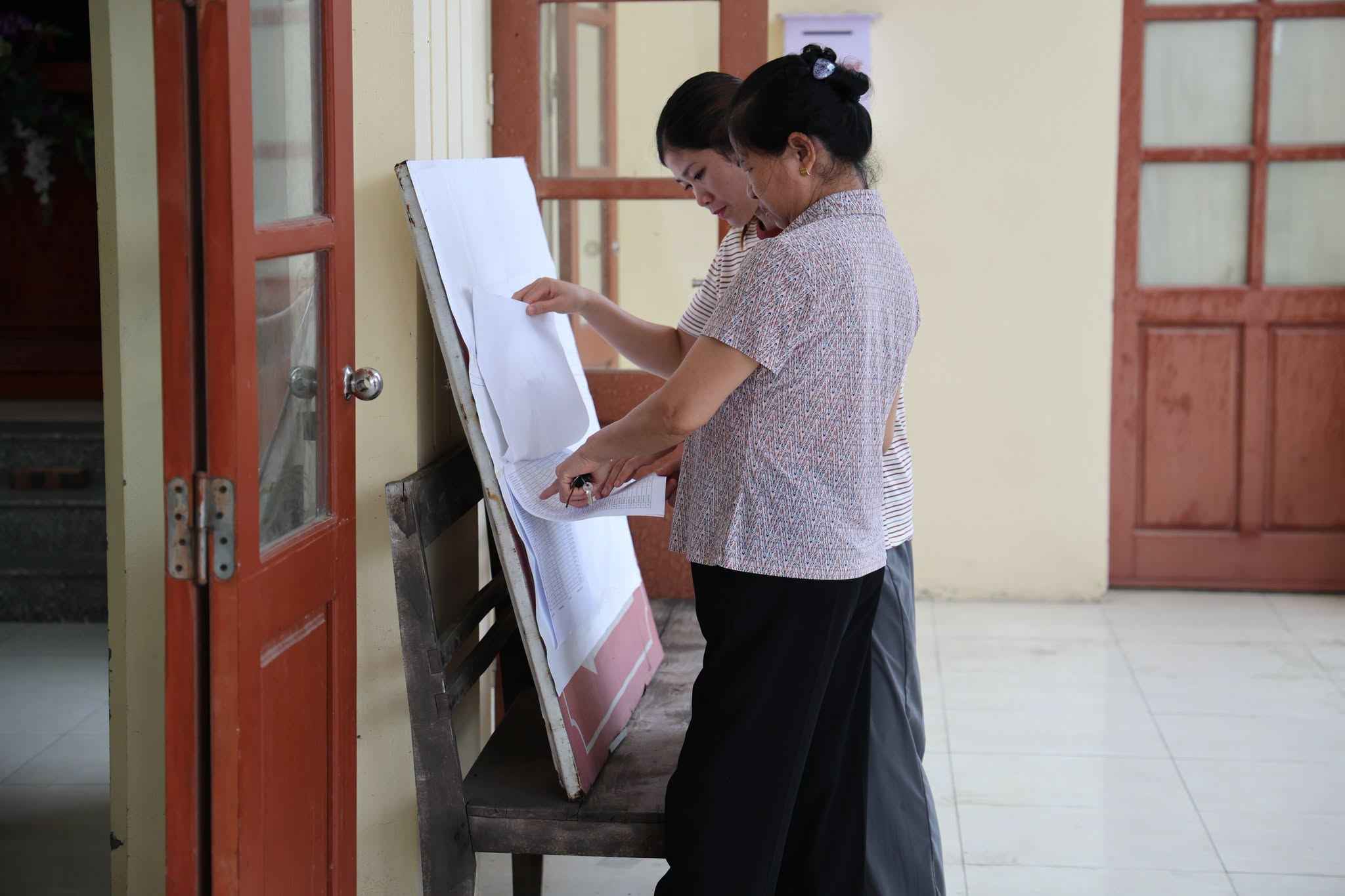 Người dân thôn Chằm tìm hiểu thông tin về công tác giải phóng mặt bằng dự án đường sắt tại bảng tin Ảnh:  Xã Gia Lộc